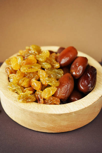 istock Dried dates and raisins in a wooden plate 2165420307