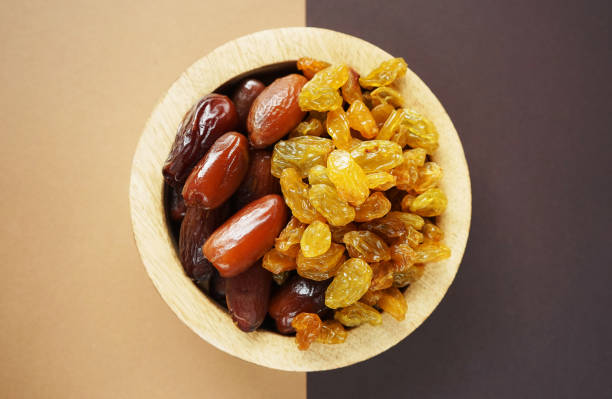Dried dates and raisins in a wooden plate