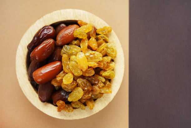 istock Dried dates and raisins in a wooden plate 2165420317