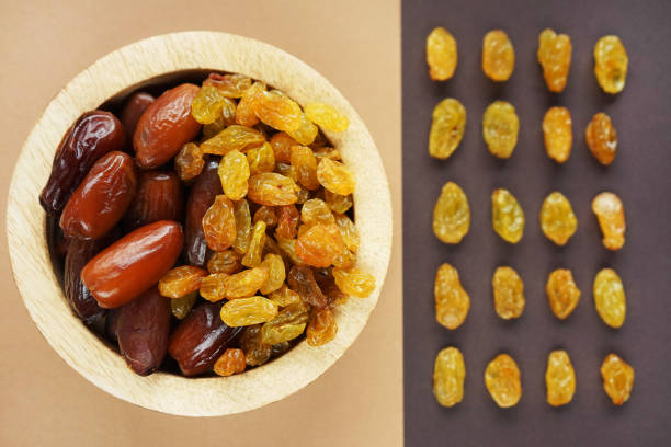 istock Dried dates and raisins in a wooden plate 2165420332