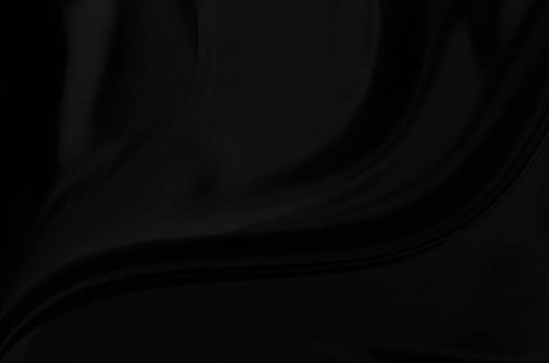 Black gray satin dark fabric texture luxurious shiny that is abstract silk cloth background with patterns soft waves blur beautiful.