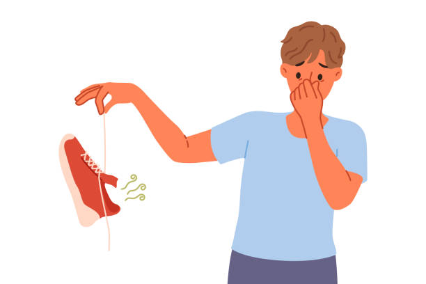 Man suffers from onychomycosis and stinky feet, covers nose with hands and holds stinky shoe Man suffers from onychomycosis and stinky feet, covers nose with hands and holds stinky shoe. Problem onychomycosis in young man requiring anti-inflammatory drugs for feet and nails kids dirty shoes stock illustrations