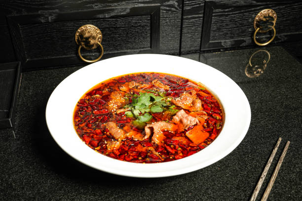 Spicy Boiled Fish with red chilli and Perfume with chopsticks served in dish on dark background top view of hong kong food