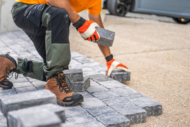 istock Worker Laying Paving Stones on a Driveway at a Construction Site in Bright Daylight 2165427287