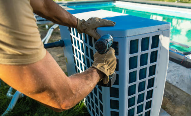HVAC Technician Installing Pool Heater Near Swimming Pool