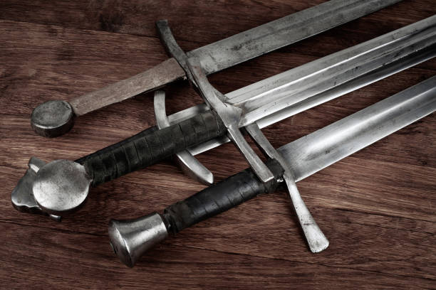 istock Medieval swords on wooden background. 2165434990
