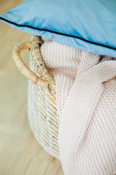 istock Home cozy interior, pink knitted plaid, jute basket. 2165439149