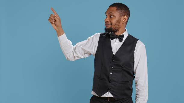 istock Doorkeeper bellhop pointing at something to left or right sides 2165440283