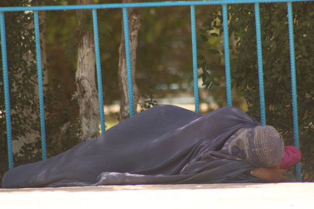 Moscow, Russia, September 16, 2024, A homeless man lies on a bench on a city street in Moscow.