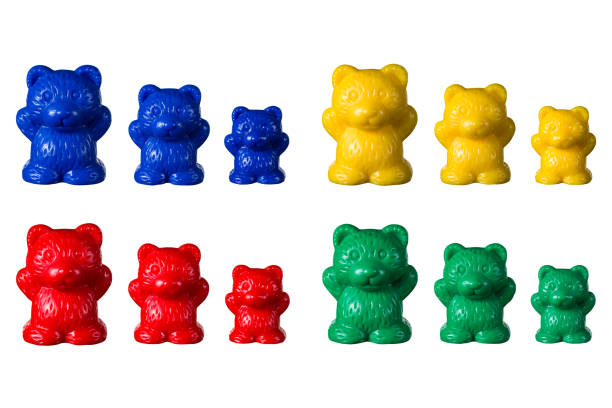 A photograph showing a set of bear counters for teaching math to school children. Plastic bears in 3 sizes and 4 different colours isolated on a white background.