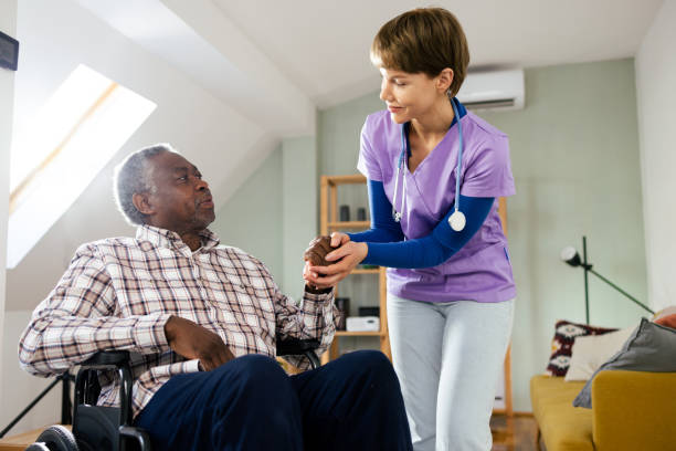 istock Geriatric nurse supporting a senior patient in a wheelchair 2165449221