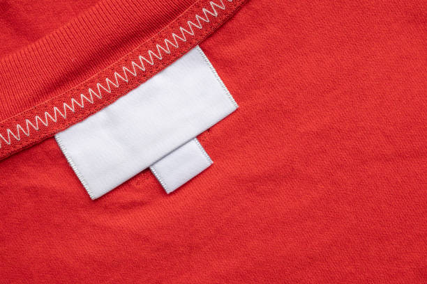 istock White blank laundry care clothes label on red shirt fabric background 2165449284