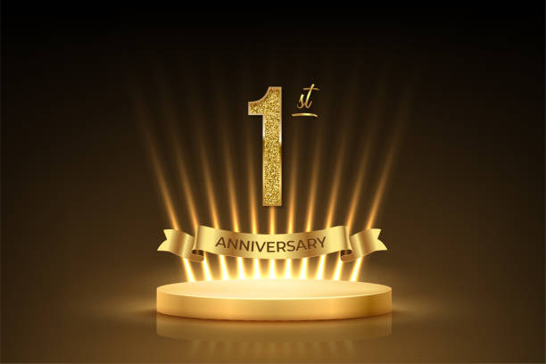 istock First anniversary gold award podium. 1 year celebration birthday or jubilee golden vector background. Luxury stage with glowing rays, glittering number 1 and ribbon with text anniversary on black 2165449762