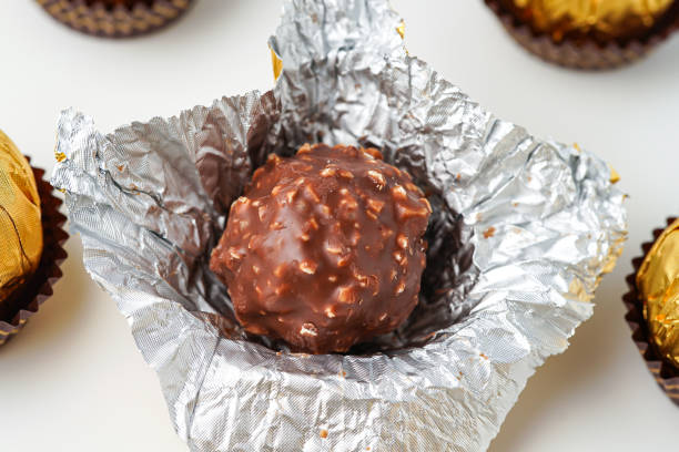 A partially unwrapped chocolate square in gold foil, a sweet treat waiting to be savored.