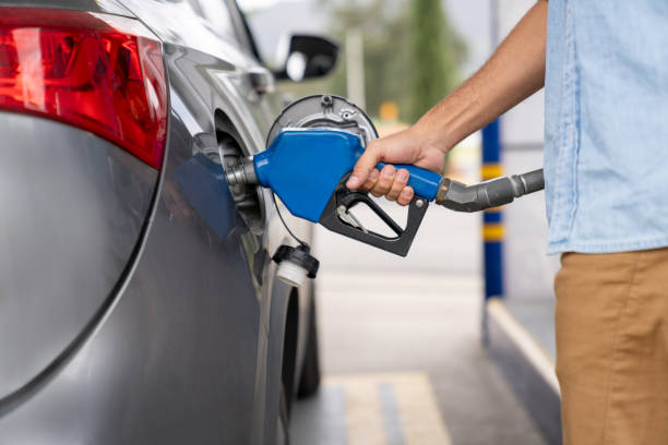 Close-up on a man refueling his car at a gas station - business concepts