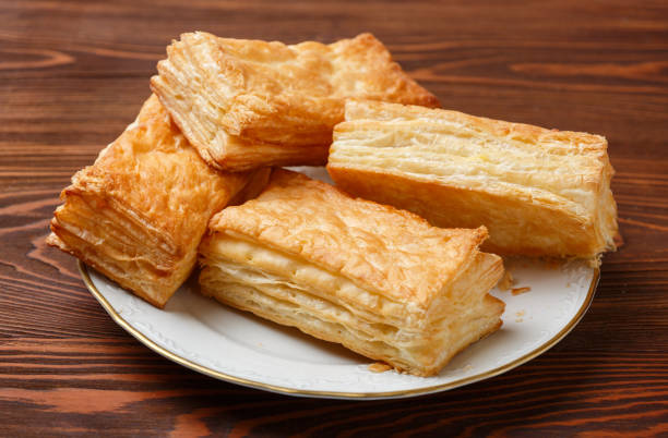 istock Delicious puff pastries in a white plate on a wooden table. Selective focus 2165462727