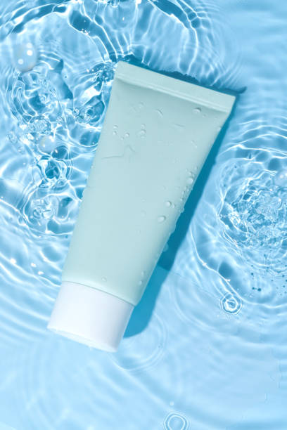 istock Unbranded face and hand cream empty plastic tube mockup on blue background water surface. Cosmetic beauty treatment, skin care, body lotion, facial cleanser, lotion, balm, hand cream, empty label. 2165463311