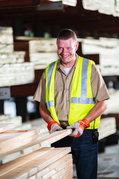 istock Mature man picking up plank in lumberyard 2165464334
