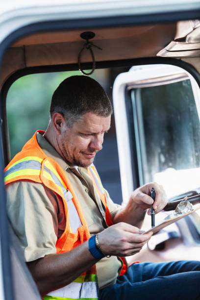 istock Truck driver writing on clipboard 2165464361