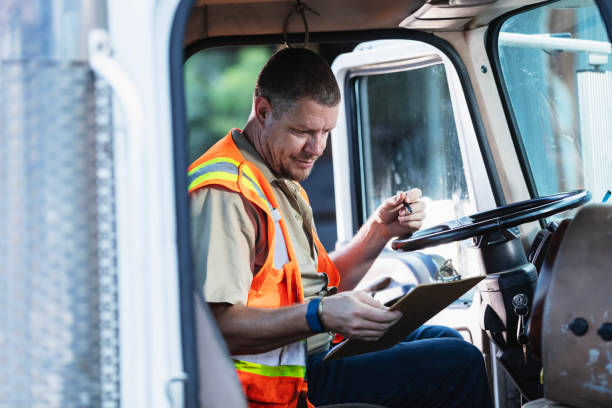istock Truck driver writing on clipboard 2165464362