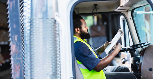 istock African-American truck driver, reading clipboard 2165464363