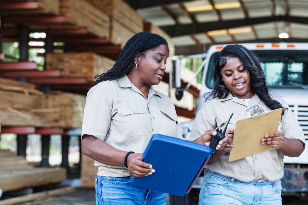 istock Two black women working at lumberyard looking at clipboards 2165464440