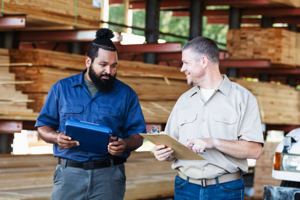 istock Two multiracial men working in lumberyard, with clipboards 2165464473
