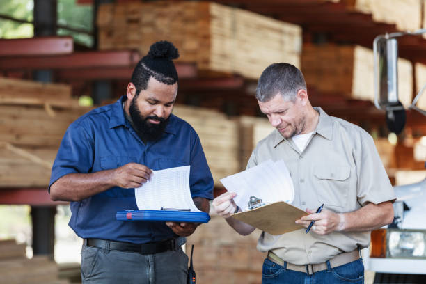 istock Two multiracial men working in lumberyard, with clipboards 2165464477
