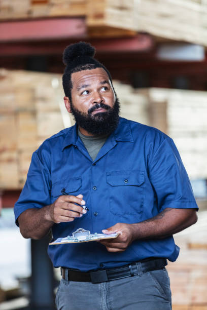 istock African-American man taking inventory at lumberyard 2165464504