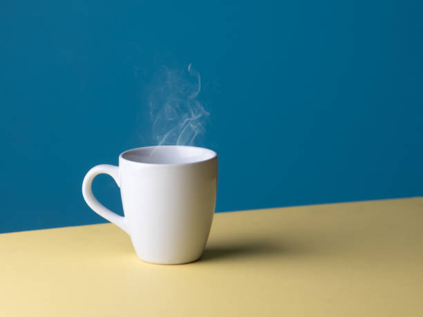 istock White hot cup of coffee with smoke on pastel blue background, copy space 2165465105
