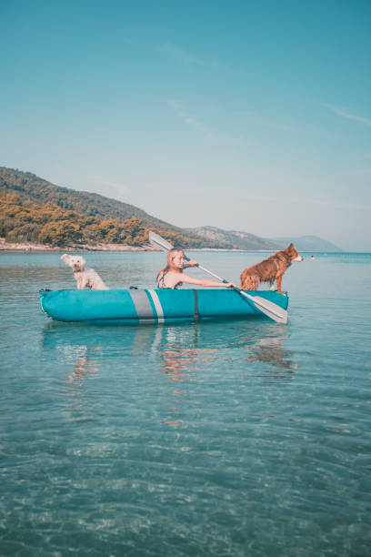 istock Young woman relaxes in inflatable raft with dog 2165468949