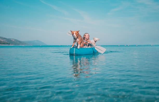 istock Young woman relaxes in inflatable raft with dog 2165468973