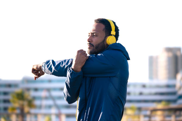 istock Active and fit male runner in warm-up stretch for running or cardio exercise. 2165470028