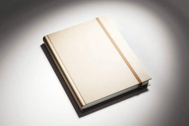 Beige hardcover book with an elastic band on a white background, spotlight effect. Concept of branding, presentation, mock up. 3D Rendering