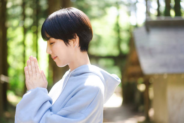 istock A woman praying at a shrine 2165471937