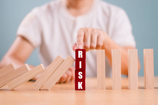 istock Risk management crisis concept. Financial analysis solution for real estate business. Hand stop economic risk. Risk word on wooden block, domino crisis reduce effect. Insurance security assessment 2165475513
