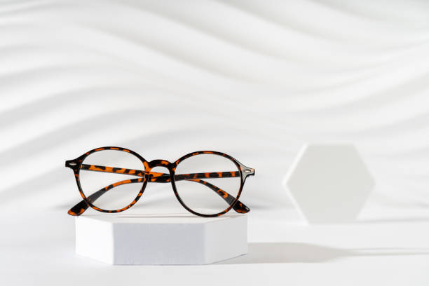 istock Unisex eyeglasses in a tortoiseshell plastic frame on podium on white background. Trendy eyewear minimal still life. Optic store discount, sale banner. Copy space. Trendy eyewear photography 2165477197