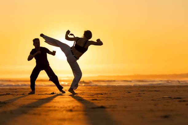 istock A man and a woman are practicing martial arts on a beach 2165478795