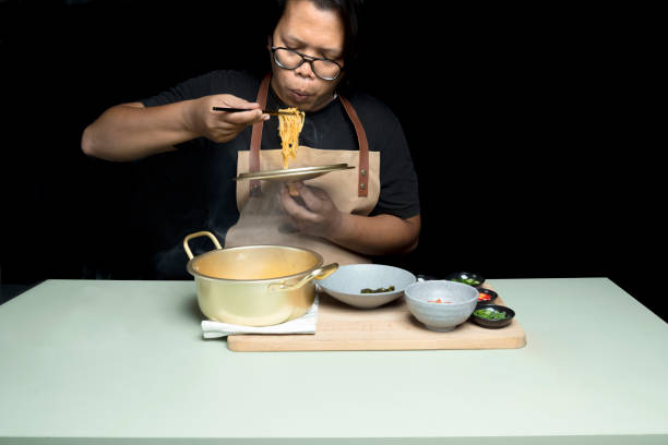 istock A man is eating instant noodles from a bowl 2165478809