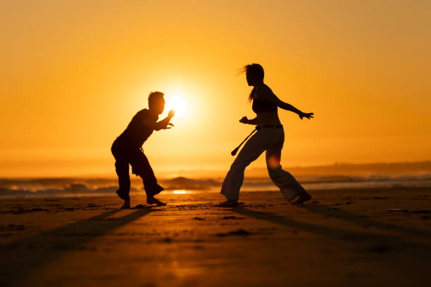 istock Two people are practicing martial arts on a beach at sunset 2165478925