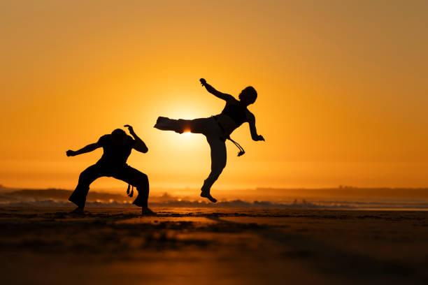 istock Two people are practicing karate on a beach at sunset 2165480813