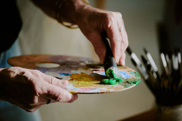 Artist Squeezing Paint From Tube Onto Palette