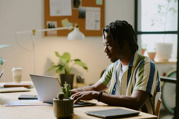 istock Gen Z Black Guy Typing On Laptop In Modern Office 2165482989
