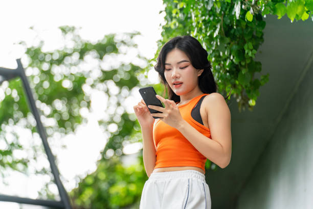 istock Young Woman Using Phone In a Park Casually 2165483180