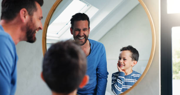 istock Morning, bathroom and dad with son or reflection, happy and playful for growth or development in house. Father, boy and mirror in home for learning facial care, grooming and bonding with love. 2165483846