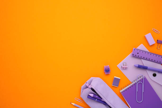 istock Flat lay composition with purple office supplies on orange background. 2165487176