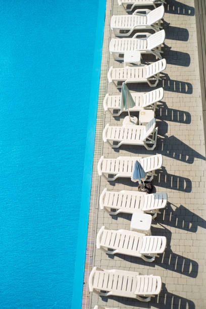 istock swimming pool with sun beds and blue water. 2165488050