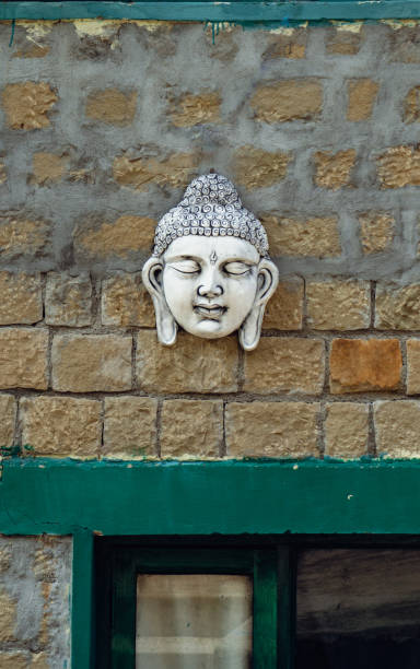 istock Buddha sculpture on an old vintage wall with graffiti. 2165488875