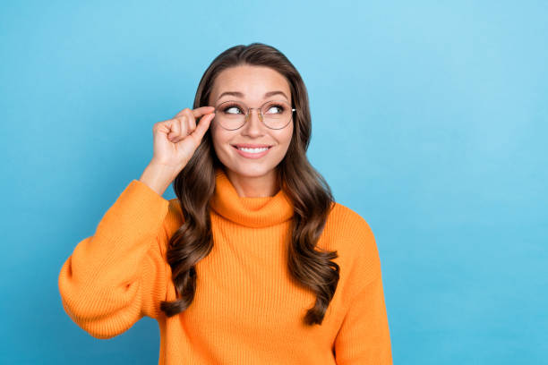 istock Photo of shiny dreamy lady dressed orange pullover arm eyewear looking emtpy space isolated blue color background 2165489920