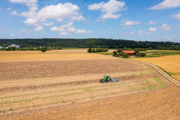 istock Tractor plowing field, aerial view 2165494012